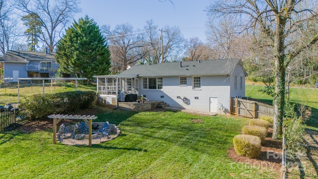 back of house featuring a sunroom, a fenced backyard, a yard, and crawl space