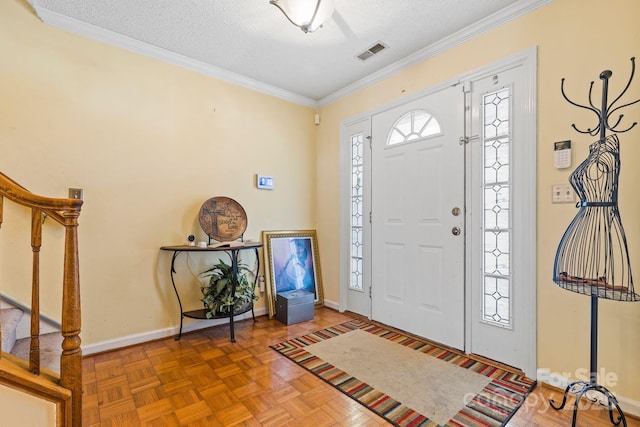 entryway with ornamental molding, visible vents, a textured ceiling, and stairs