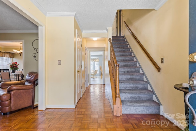 entrance foyer featuring a textured ceiling, ornamental molding, and a wealth of natural light