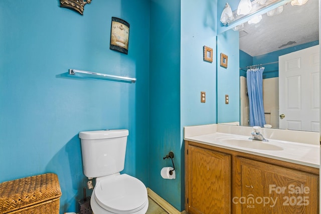 bathroom with curtained shower, vanity, toilet, and baseboards