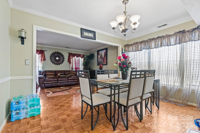 dining space featuring an inviting chandelier, a textured ceiling, visible vents, and a wealth of natural light