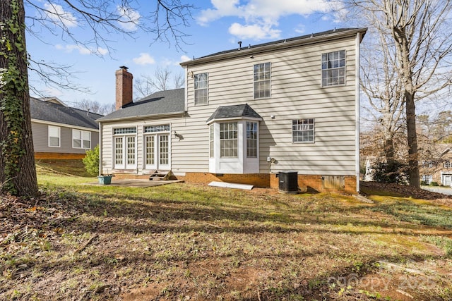 back of house featuring entry steps, french doors, a chimney, crawl space, and a yard