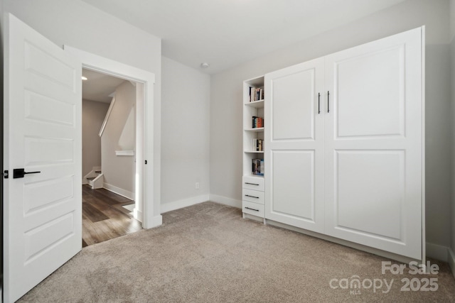 unfurnished bedroom featuring baseboards and light colored carpet