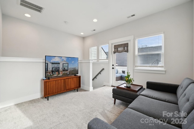 carpeted living area with baseboards, visible vents, and recessed lighting