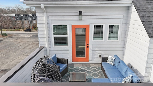 doorway to property with a shingled roof and an outdoor living space