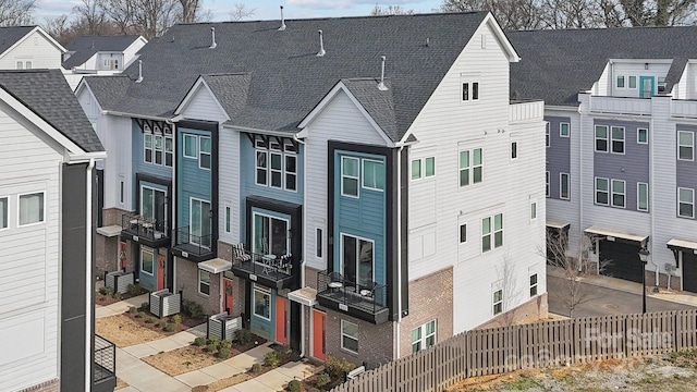 exterior space featuring a shingled roof and fence