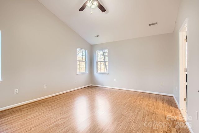 empty room featuring ceiling fan, lofted ceiling, visible vents, baseboards, and light wood-style floors