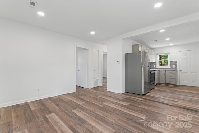 kitchen featuring recessed lighting, gray cabinetry, stainless steel appliances, visible vents, and dark wood-style floors