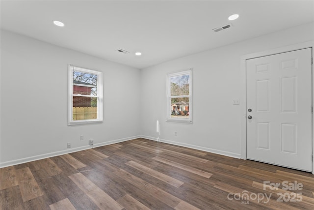 spare room featuring visible vents, a wealth of natural light, and wood finished floors