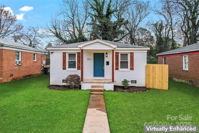 bungalow-style house with brick siding, crawl space, cooling unit, and a front lawn