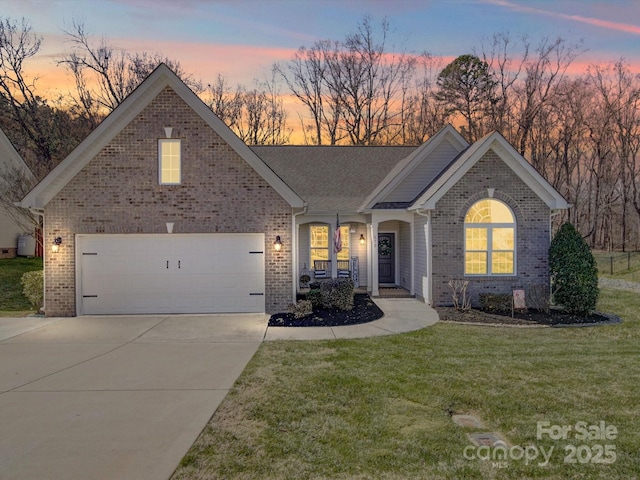 view of front of house with brick siding, a lawn, and driveway