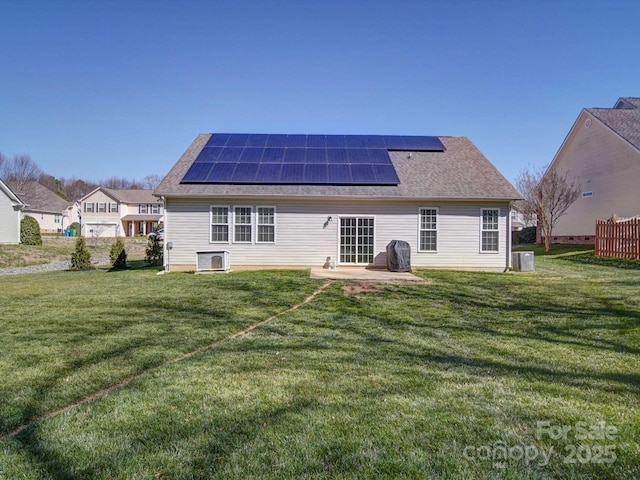 back of property with a lawn, a patio, and solar panels