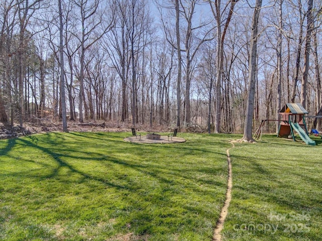 view of yard with playground community and a fire pit