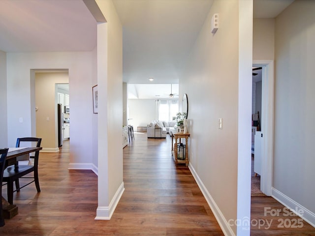 hallway featuring baseboards and dark wood finished floors