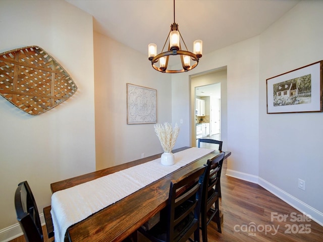 dining area featuring an inviting chandelier, wood finished floors, and baseboards