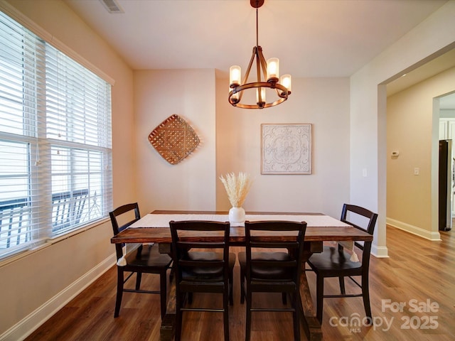 dining area with an inviting chandelier, baseboards, and wood finished floors