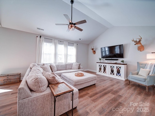 living room featuring lofted ceiling, visible vents, ceiling fan, and wood finished floors