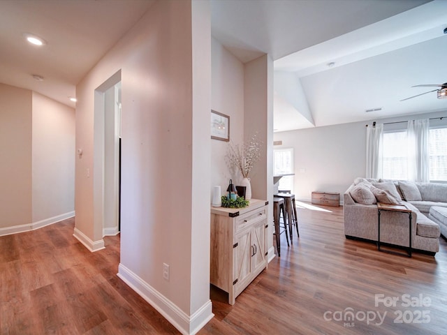 hall with lofted ceiling, light wood-style floors, baseboards, and recessed lighting