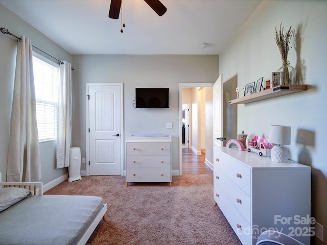 bedroom featuring light carpet, ceiling fan, and baseboards