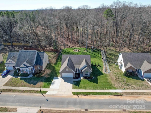 bird's eye view with a wooded view