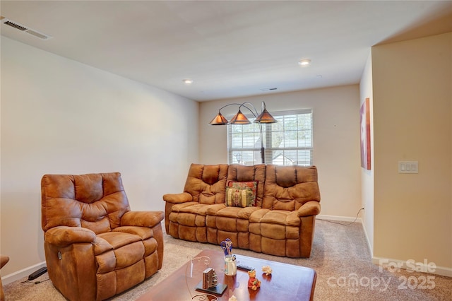 living area featuring baseboards, visible vents, and light colored carpet