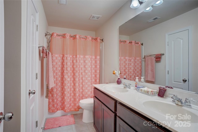 bathroom featuring toilet, double vanity, visible vents, and a sink