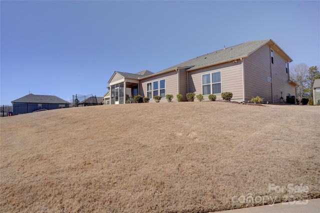 exterior space with a front yard, cooling unit, and fence