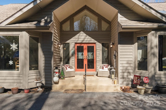 entrance to property with french doors and a shingled roof