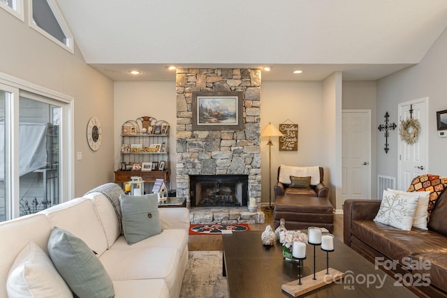 living room featuring recessed lighting, visible vents, a fireplace, and wood finished floors