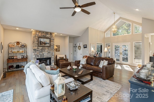 living room with visible vents, wood finished floors, french doors, a fireplace, and high vaulted ceiling