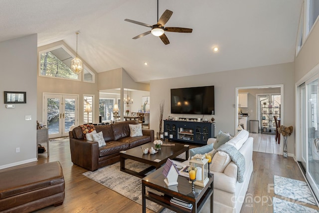 living area with high vaulted ceiling, french doors, wood finished floors, and baseboards