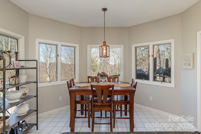 dining space featuring light tile patterned floors, plenty of natural light, and baseboards