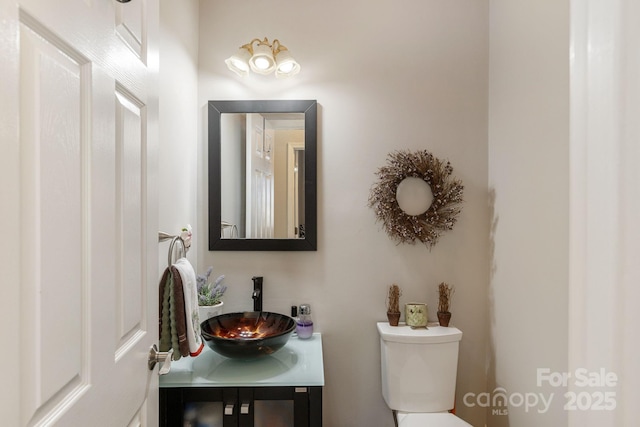 half bathroom with toilet and vanity