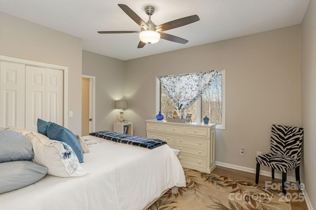 bedroom with ceiling fan, a closet, light wood-type flooring, and baseboards