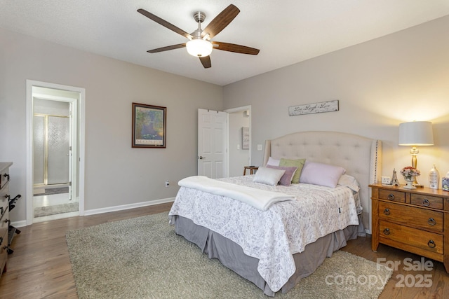 bedroom featuring ensuite bathroom, ceiling fan, baseboards, and wood finished floors