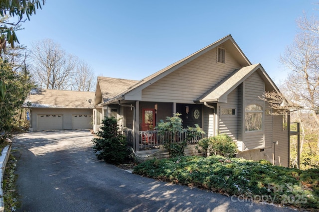 view of front of property featuring a garage, aphalt driveway, and covered porch