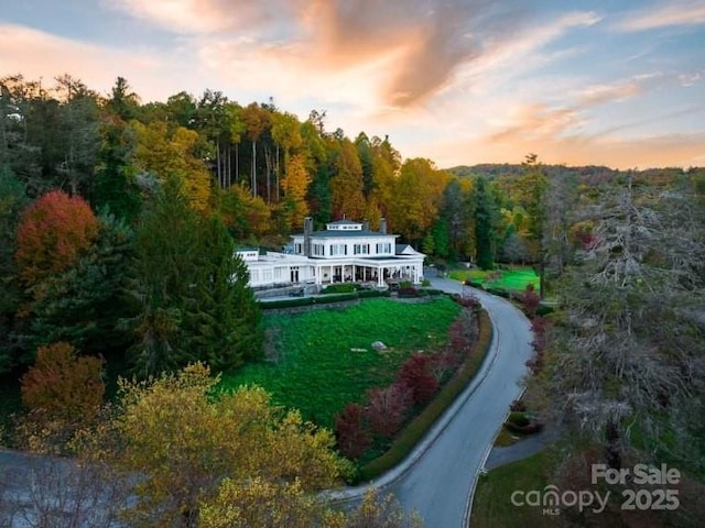 aerial view at dusk with a wooded view