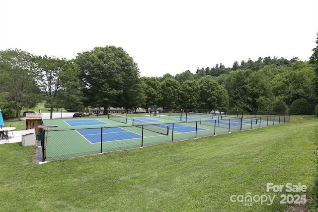 view of tennis court with fence and a yard