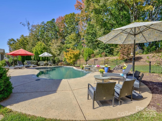 view of swimming pool with a pool with connected hot tub, a patio, and fence