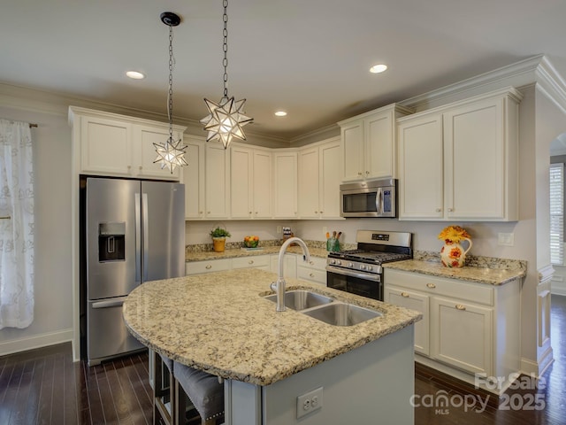 kitchen featuring stainless steel appliances, dark wood-style flooring, a kitchen island with sink, and a sink