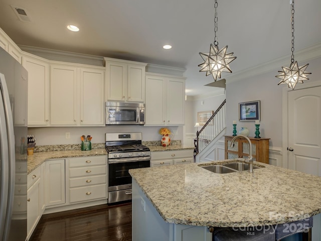 kitchen with visible vents, white cabinets, appliances with stainless steel finishes, ornamental molding, and a sink