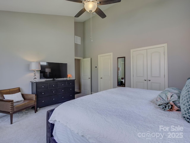 bedroom featuring high vaulted ceiling, carpet floors, visible vents, a ceiling fan, and a closet