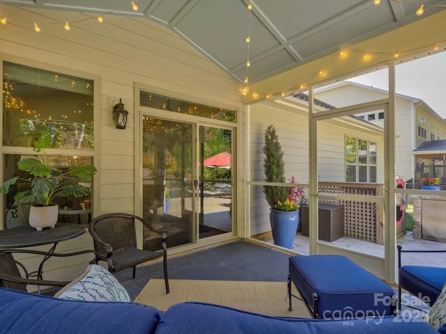 sunroom featuring lofted ceiling and plenty of natural light