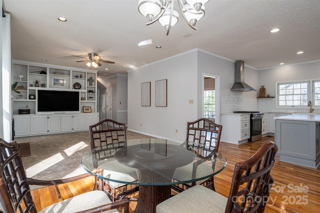 dining area with a wealth of natural light, a textured ceiling, light wood-type flooring, and baseboards