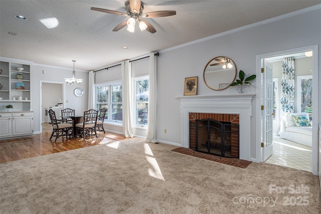 unfurnished living room with carpet floors, a textured ceiling, ornamental molding, and a fireplace