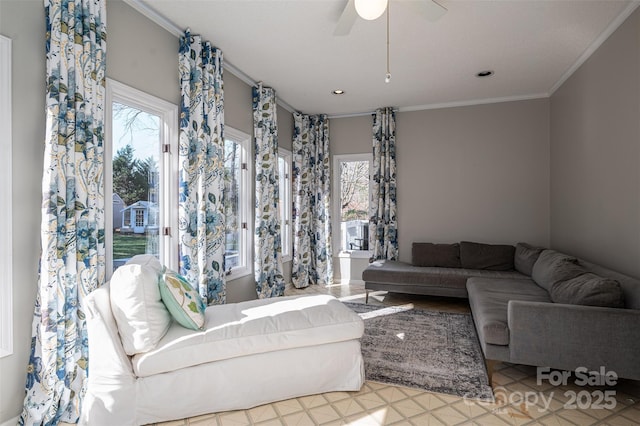 living area featuring crown molding, plenty of natural light, and ceiling fan