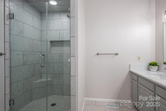 bathroom featuring visible vents, a stall shower, vanity, and baseboards