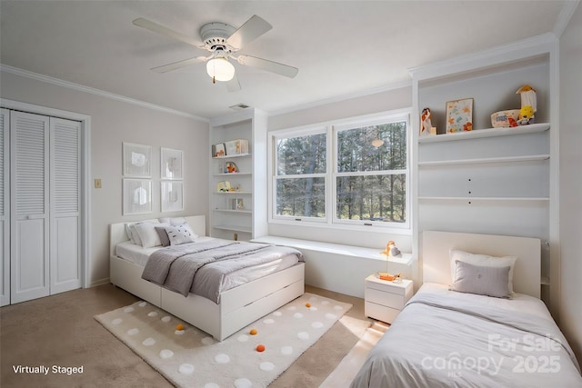 carpeted bedroom with visible vents, a closet, ceiling fan, and crown molding