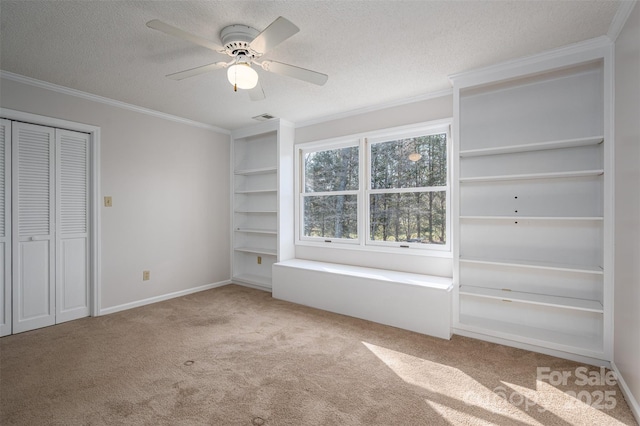 unfurnished bedroom with visible vents, ornamental molding, a textured ceiling, and carpet floors