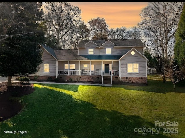 rear view of house with a lawn, covered porch, and crawl space
